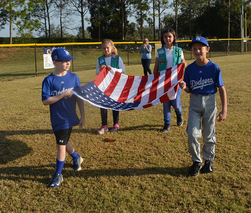 Dodgers Kayden West and Ethan Eddy along with Girl Scouts Addison Hurt and Hailey Lopez-Lanuza present the colors on opening day.