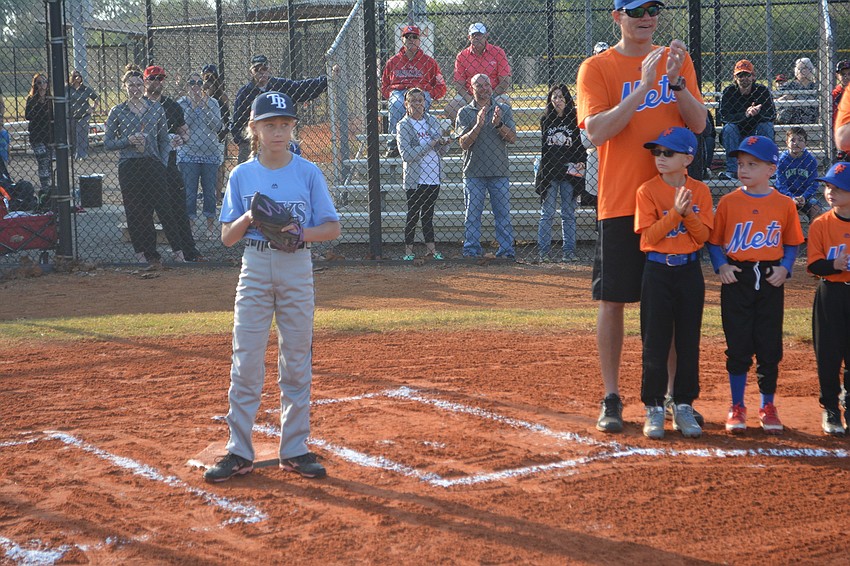 The Rays'    Taryn Eddy of the Minors division had the honor of catching the opening pitch thrown by Manatee Food Bank'   s Tony DeFilippo.