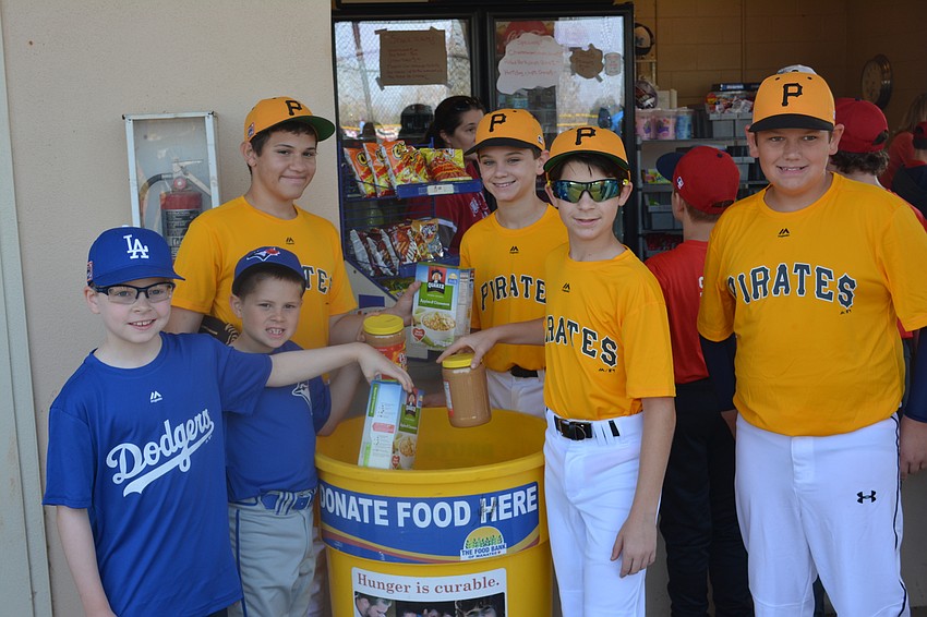 Dodger Kayden West, Blue Jay Tryston Hurt and Pirates Nicholas Marrero, Michael Price, Austin Murkerson and Michael Kasper show how the opener helps collect donations for the Food Bank of Manatee.