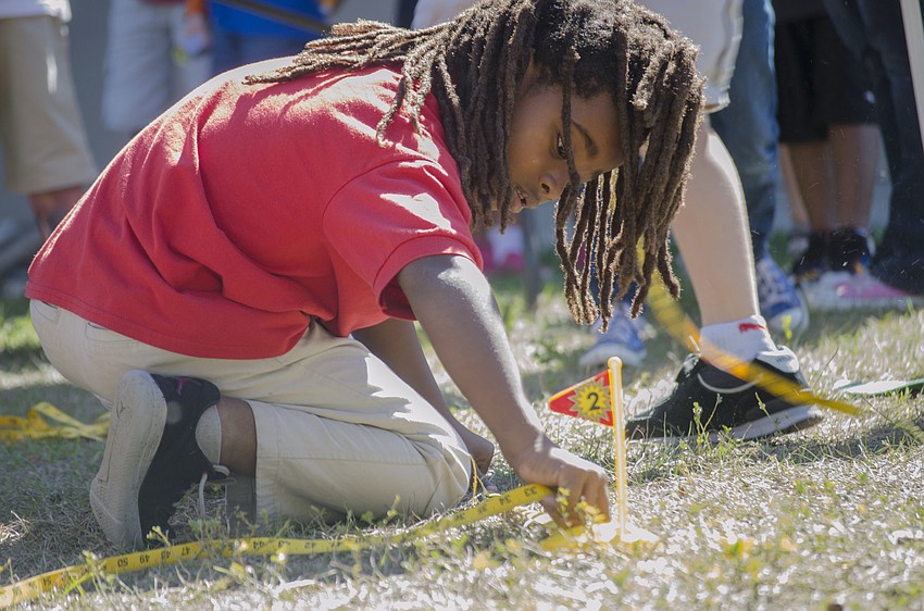 Tavaris Taylor measures how far his golf ball came to the target.