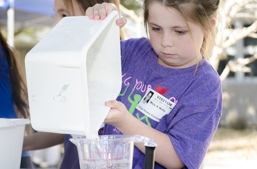 Brooklyn Gryscowka measures how much water she squeezed from a sponge.