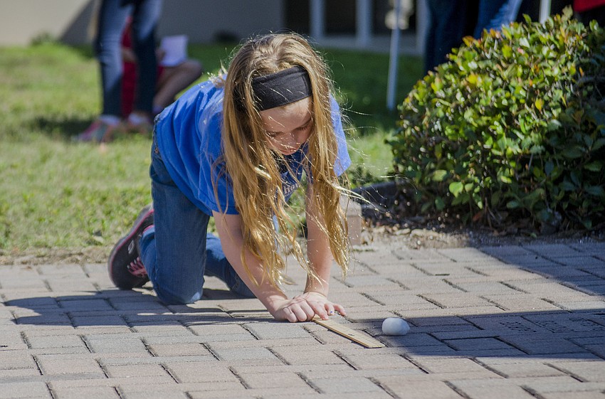 Emma Passifiume measures how far she threw her cotton ball