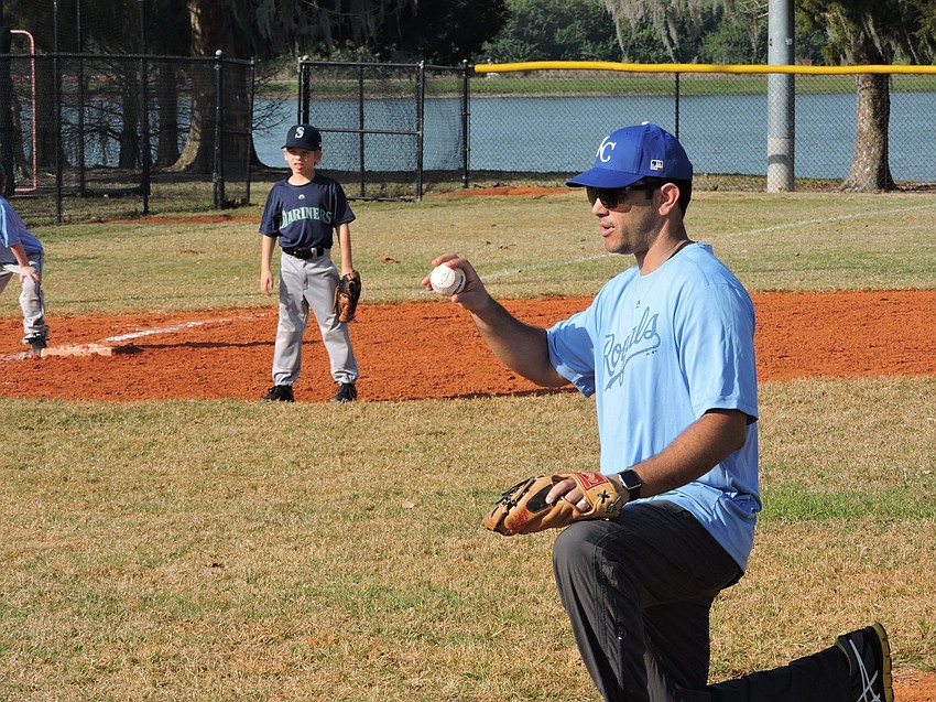 Royals coach Jason Lazaris gets ready to deliver to home plate in the Coach Pitch division.