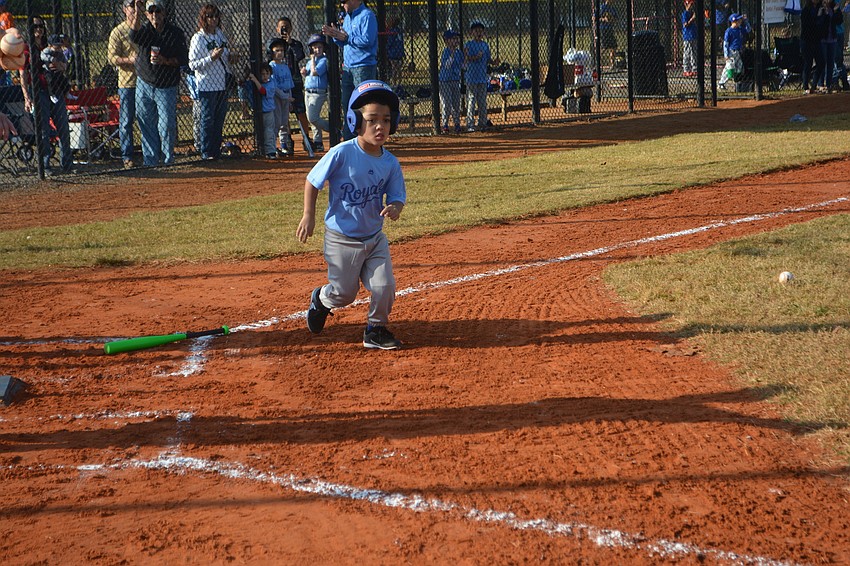 Isaiah Perry of the Royals heads to first base after hitting the ball.
