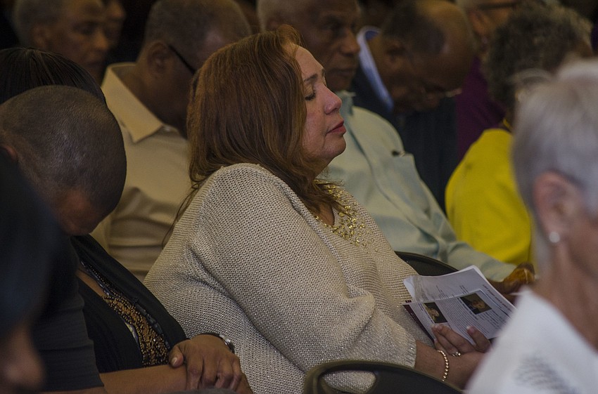 Kathy Byrdpobee reacts to Pastor John Wesley Walker'    s prayer at the beginning of the ceremony.