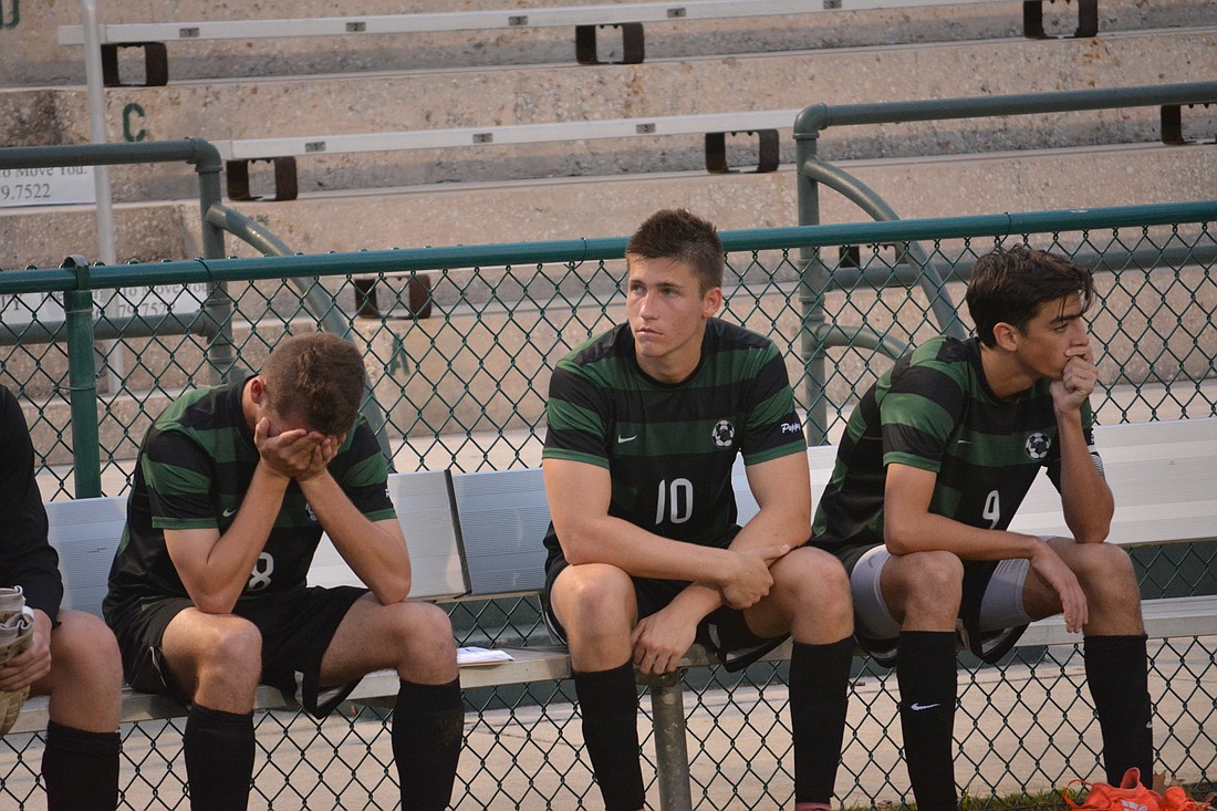 Sam Stapleton-Jones, Tyler Puhalovich and Connor Bezet sit on the bench after the game.