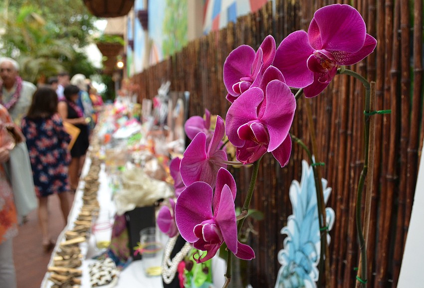 The silent auction table was adorned with orchids and bamboo to add to the Hawaiian theme of the event.
