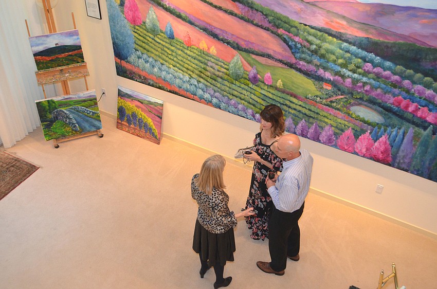 Susan Kelley explains a piece to Darcie and Guy Allen at the reception on Feb. 23 at William Kelley Studio.