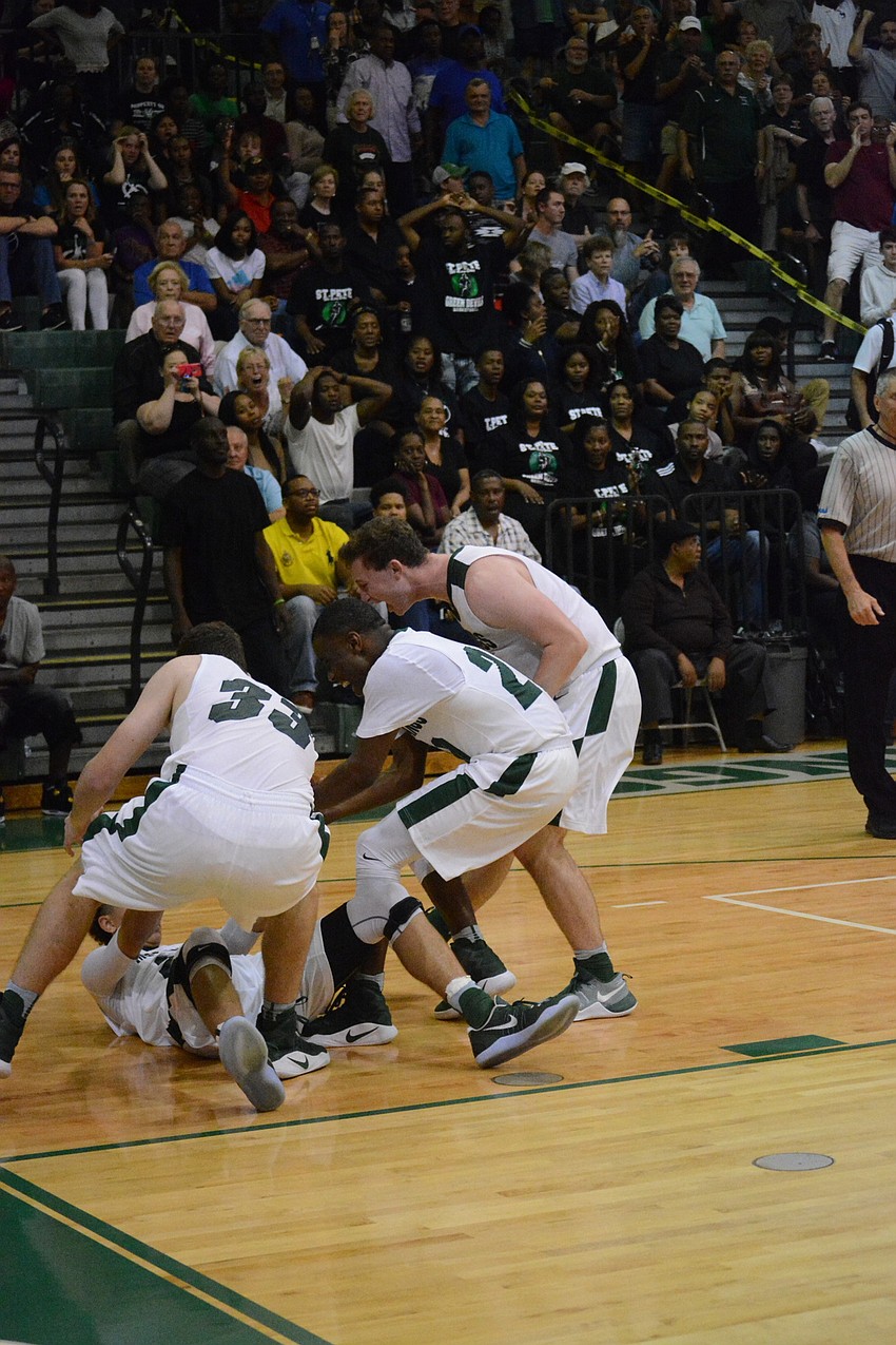 Justin Muscara, Devin Twenty and Sam Hester rush to pick up Evan Spiller after Spiller'    s late-game steal and a foul.