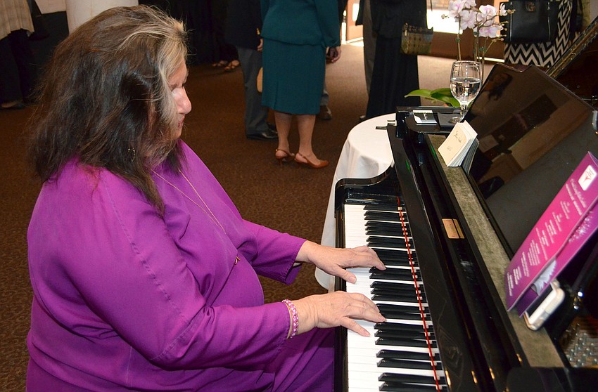 Diana Harrington performs several pieces on the piano for guests to enjoy during the open reception.
