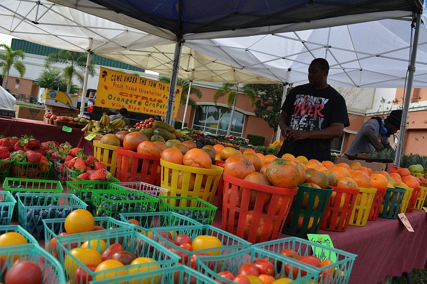 Come Under the Yum Yum Tree set up fresh fruits and vegetables for the farmer'   s market.