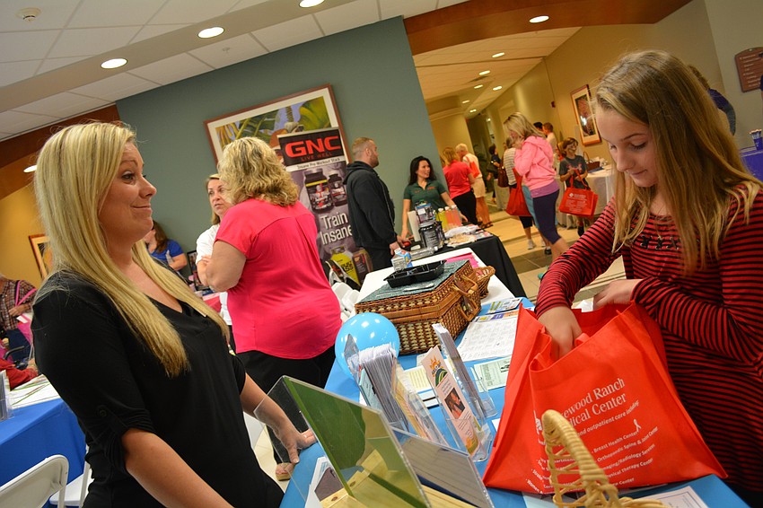 Thylla Thomas of Meals on Wheels PLUS offers goodies to Jadyn Ganas, 10, of Parrish.