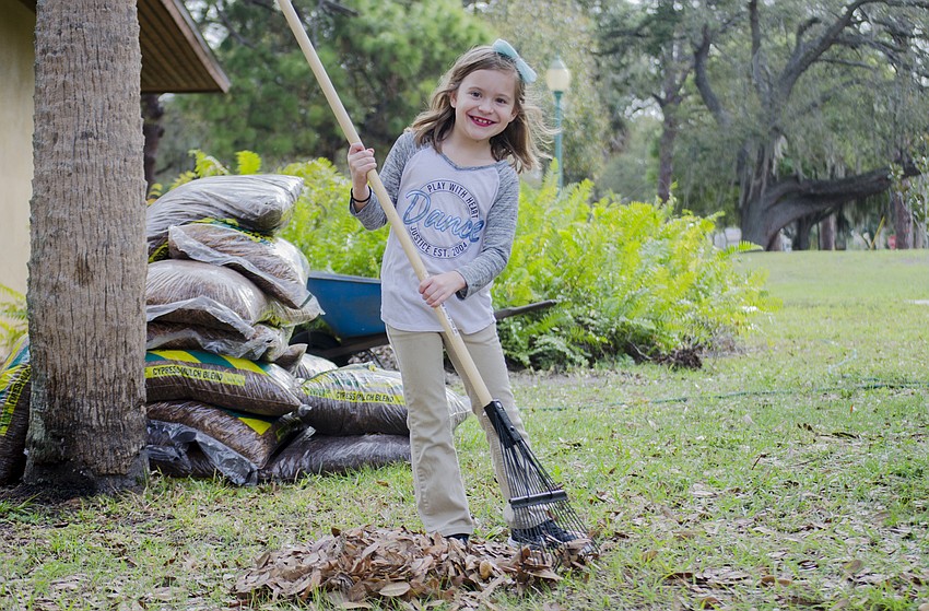 Savanah Montes rakes leaves in Gillespie Park as part of the neighborhood'   s workday.
