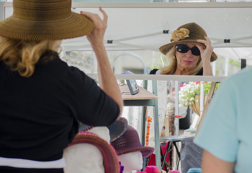 Susan Jordan tries on a hat at Le Marche Behemien.