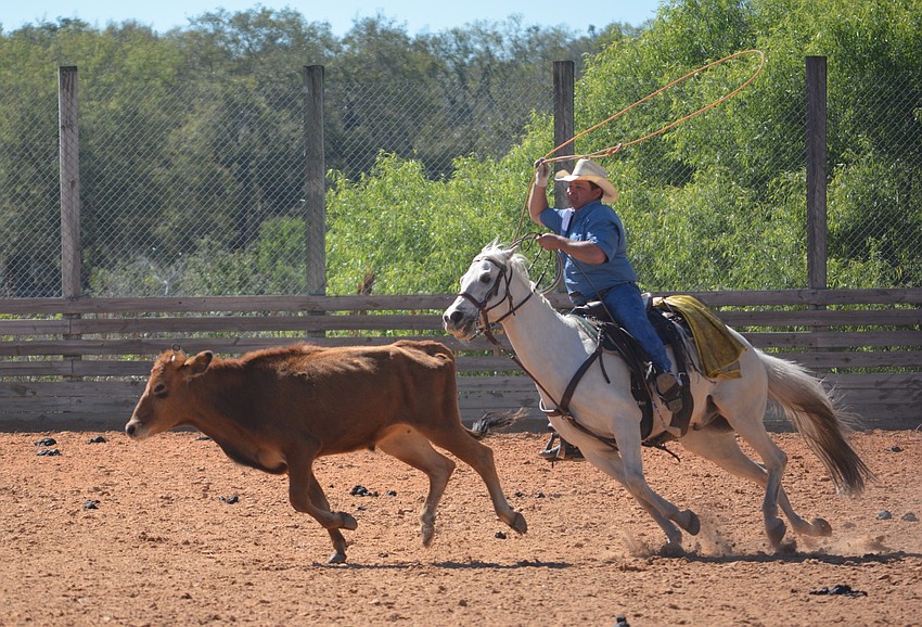 Steve John, the citrus production manager for Schroeder-Manatee Ranch, shows the competitors how roping a steer is done.