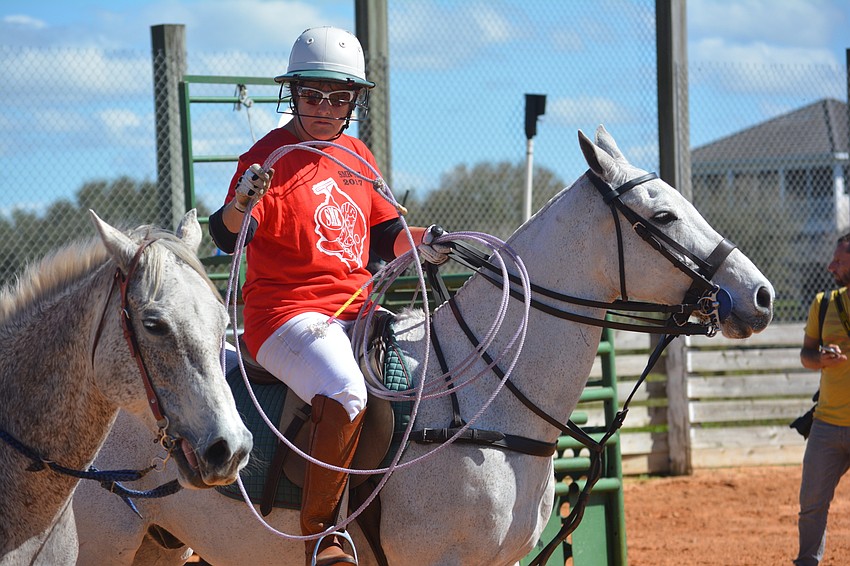 Polo player Ann Oniskey practices with a lariat before her attempt at roping.