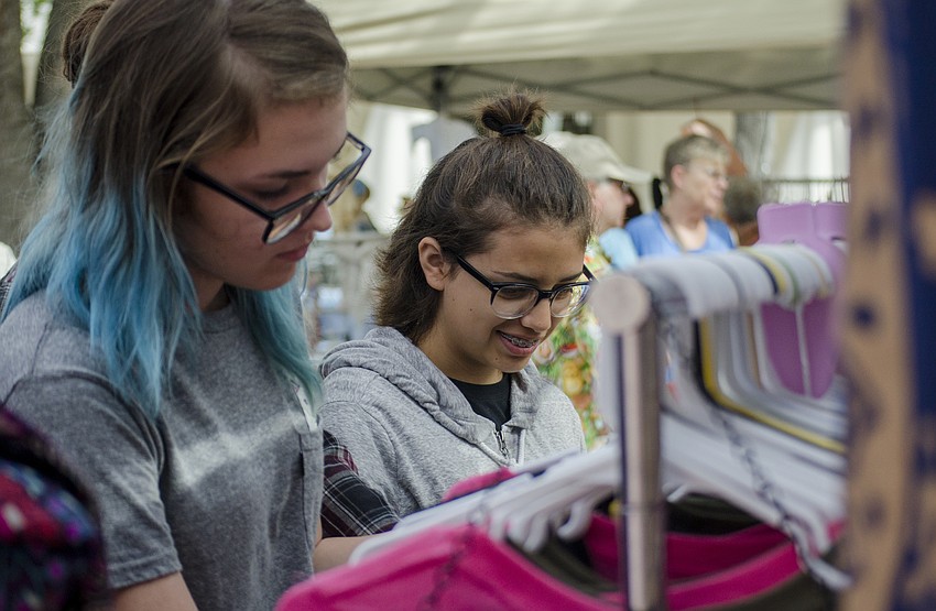 Samantha Ehrhardt and Maya Lana look through clothes at the Knot + Loop booth.