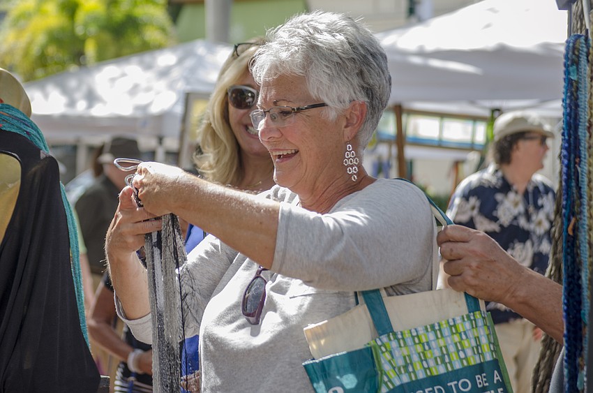 Teresa Wetzel tries on a scarf.