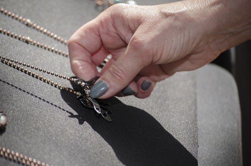 Marilyn Carroll looks at a necklace.