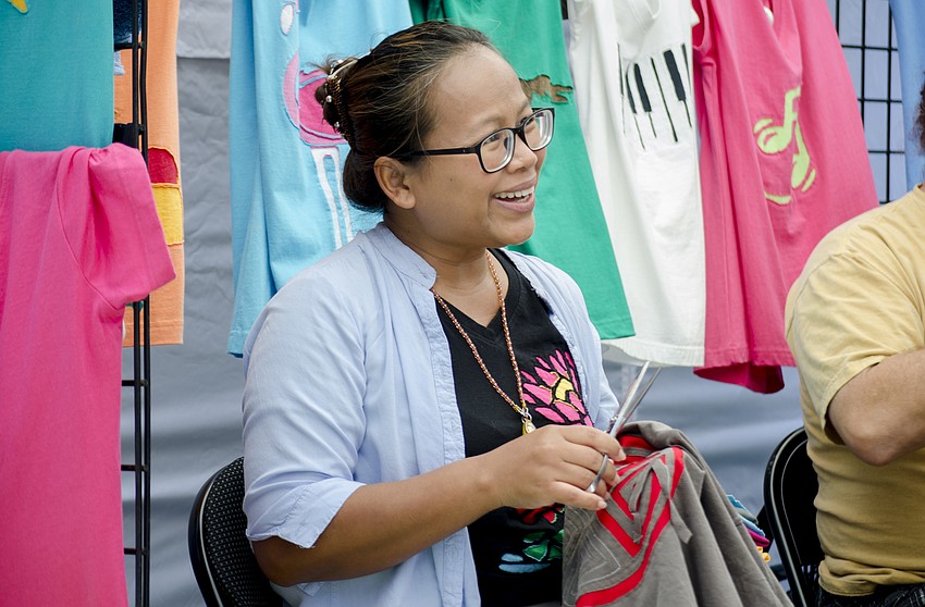 Sawai McLaughlin chats with a customer as she works on one of her custom T-shirts.