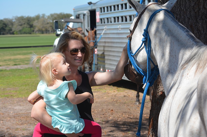 Ellie Arthur and mom Mandy Arthur check out the horses before the Observer Cup at the Sarasota Polo Club.