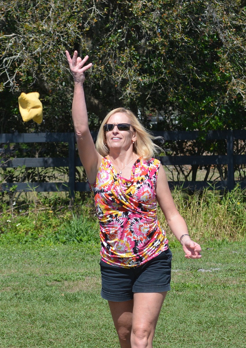 Lakewood Ranch'  s Karen Stevens enjoys some cornhole before the The Observer Cup at the Sarasota Polo Club.