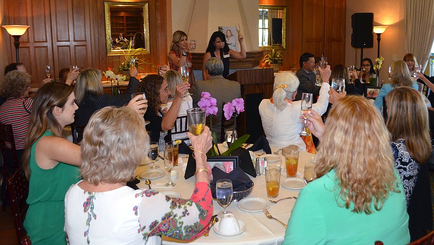 o-Chairwomen Michelle Senglaub and Kay Mathers lead a toast for the late Nikki Nilon at the annual Girls Inc. Honoree Luncheon on March 1 at The Field Club.