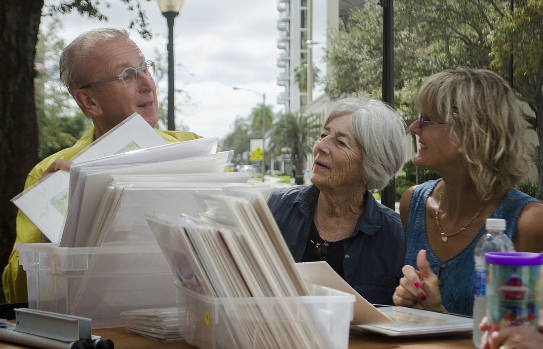 Jerome Chesley helps Ellen McKeefe and Karen Jackson price the pieces that will be sold at the Sarasota Urban Sketchers art sale March 2.
