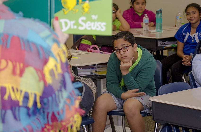 Mohammed Abumunshar listens to School Board member Caroline Zucker as she reads 