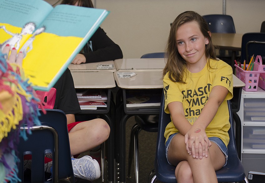 Lily Minahan  listens to School Board member Caroline Zucker as she reads 