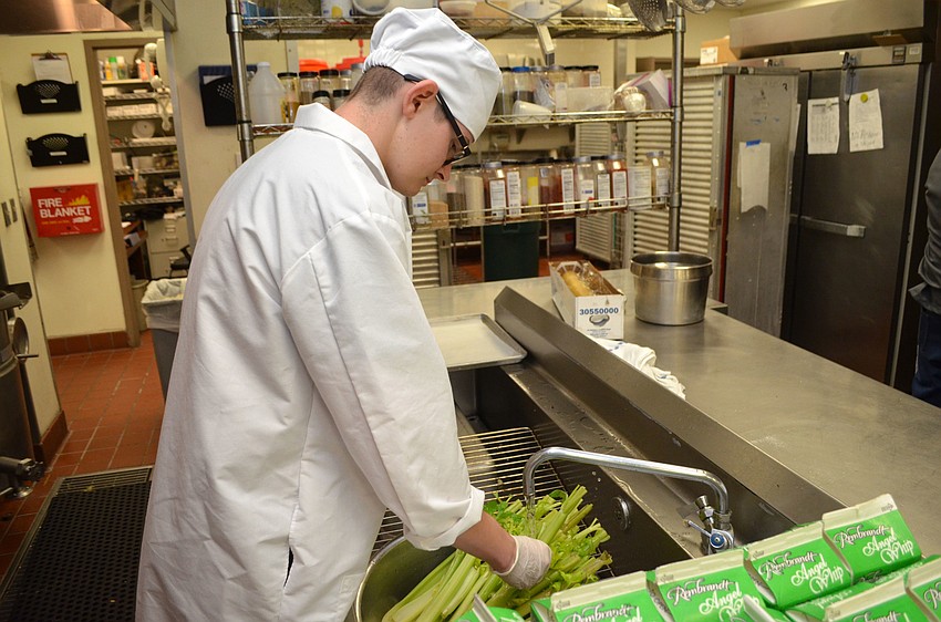 USF student Ben Martin washes vegetables to be included in the meal for guests at HospitaBull on March 2 at The Ritz-Carlton, Sarasota.