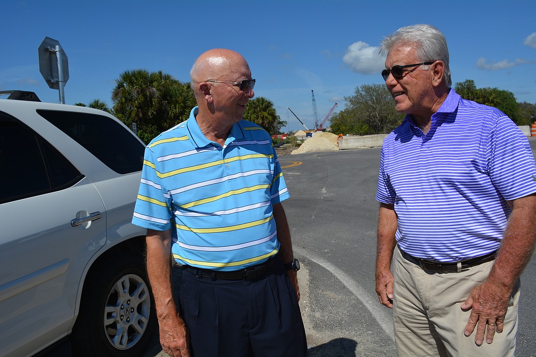 Waterlefe residents Bill Gratsch and Ken Bumgarner stand near Waterlefe&#39;            s back entrance, where Upper Manatee River Road eventually will connect with the Fort Hamer Bridge.