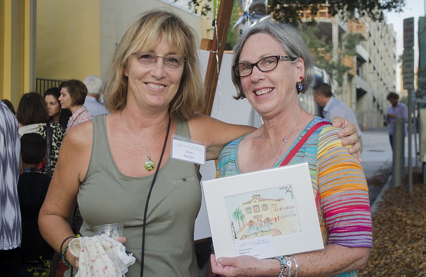 Kim Parker poses with Janine Riley. Riley had just purchased one of Parker'   s submissions to the sale.