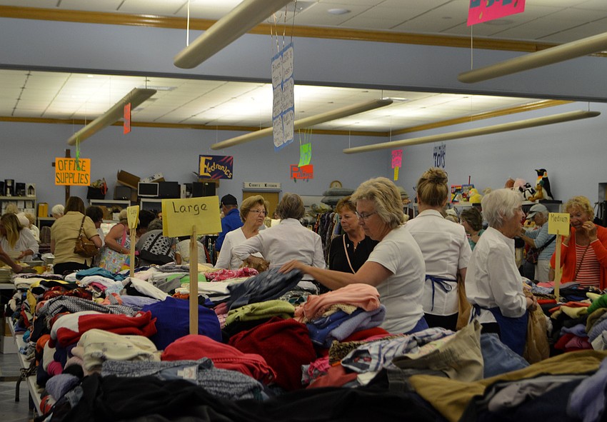 Customers rummage through the clothing tables during the early bird sale on March 3.