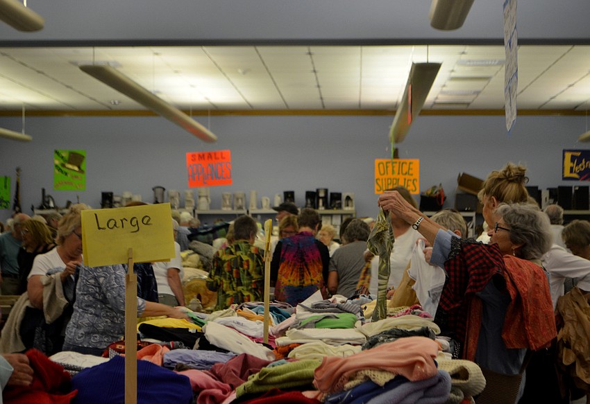 Customers rummage through the clothing tables during the early bird sale on March 3.