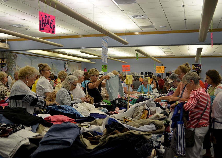Customers rummage through the clothing tables during the early bird sale on March 3.