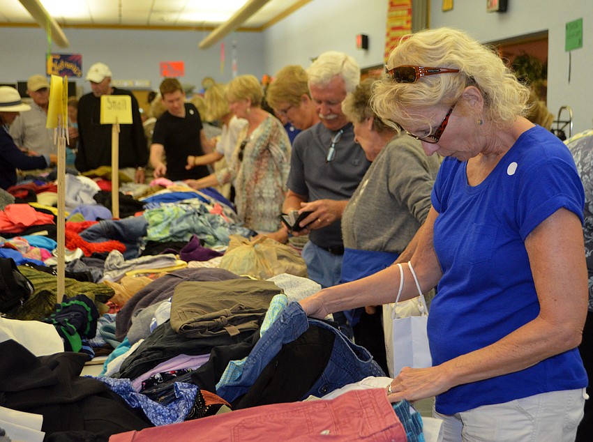 Linda Delano looks at the ladies’ clothing tables at the early bird sale on March 3.