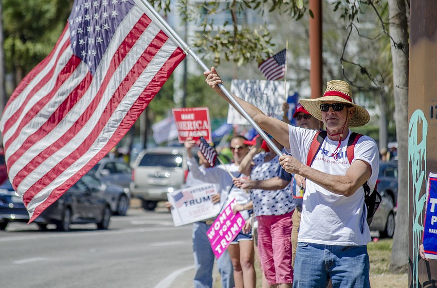 Phil Linebarger waves an American flag as part of the Spirit of America Rally.