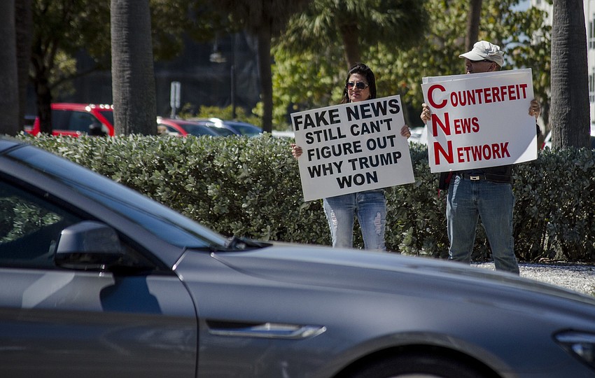 Demonstrators hold signs near the intersection of N. Tamiami Trail and Gulfstream Avenue.