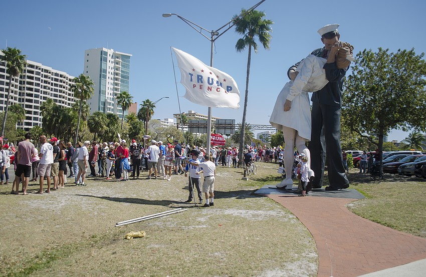 A Trump campaign flag waves in the wind in front of the Unconditional Surrender statue.