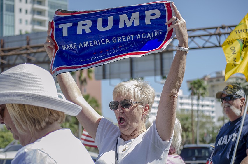 Pat MacInnis holds a Trump campaign sign during the Spirit of America Rally.