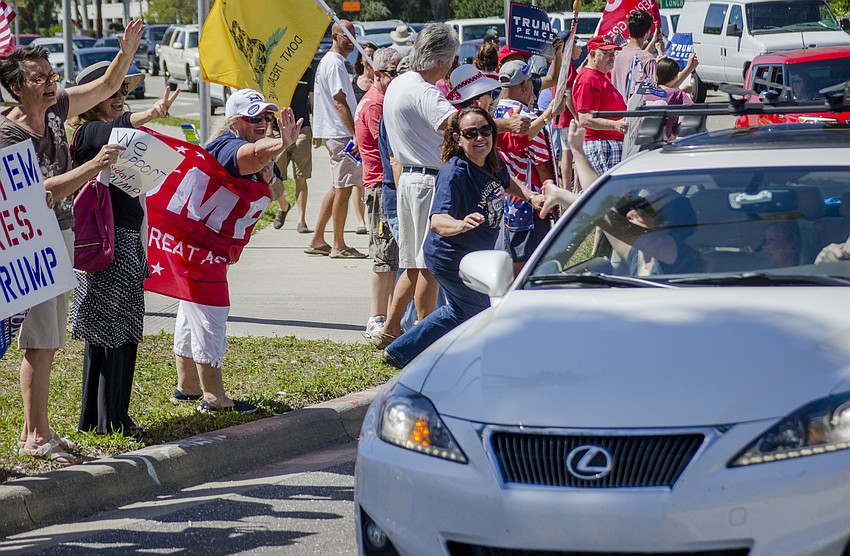 A passing motorist gives demonstrators a thumbs down.