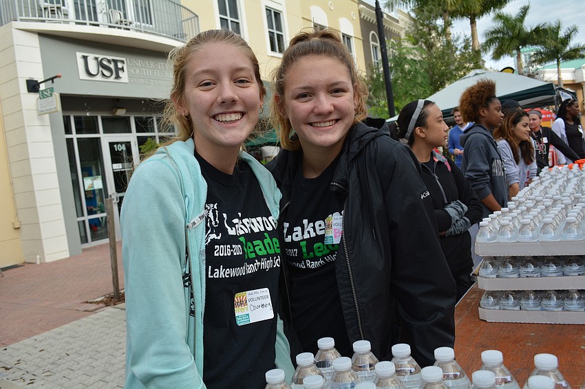 Lakewood Ranch High School students Courtney and Bella Yost pass out water to runners as they finish.
