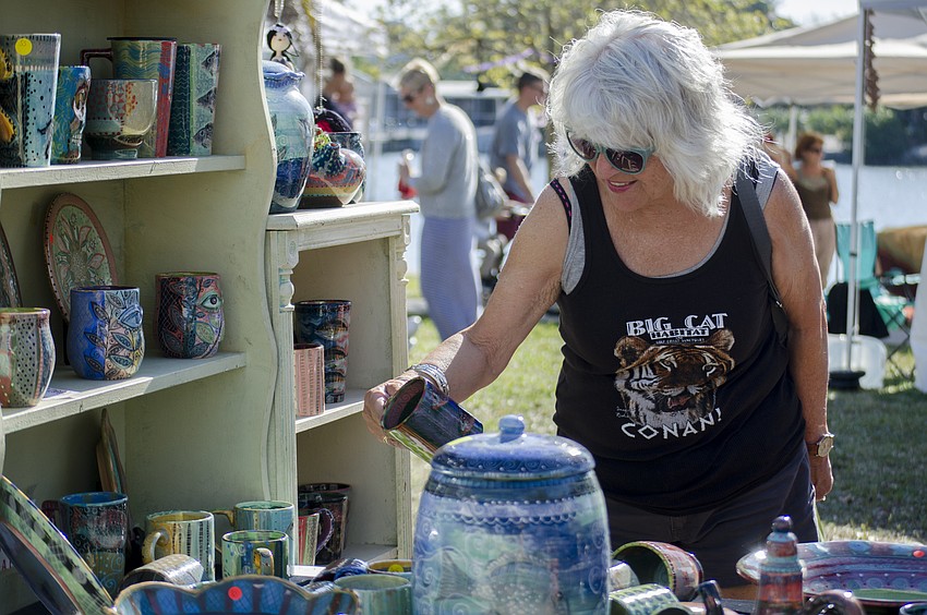Barbara Collings browses hand painted pottery at the Pam Design booth.