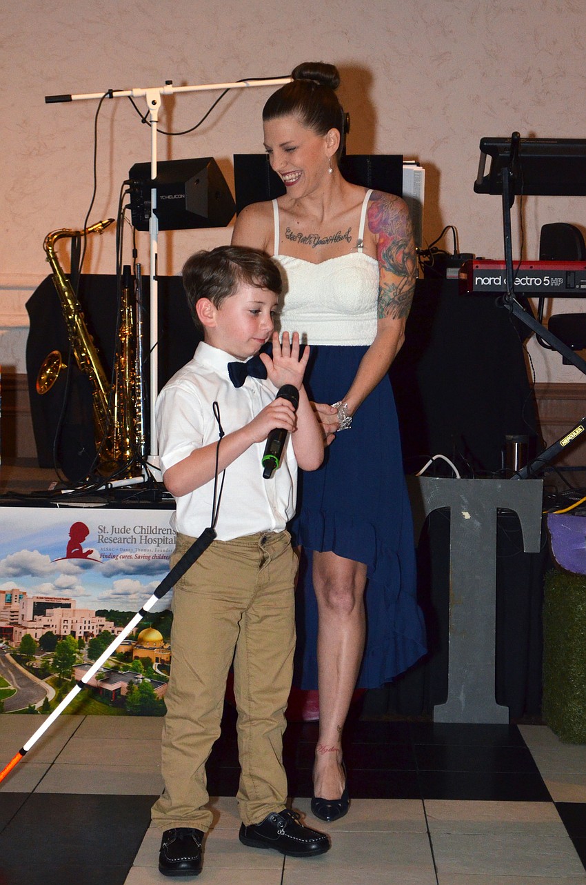 Tiffany Henke laughs as her son, Ayden Morgan, prepares to sing “Fight Song” by Rachel Platten at Foodlosophy on March 10 at Michael’s On East.