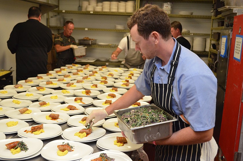 Derek Blackburn plates his fourth course dish of BBQ shrimp and pork sausage with Memphis-style coleslaw and corn souffle at Foodlosophy on March 10 at Michael’s On East.