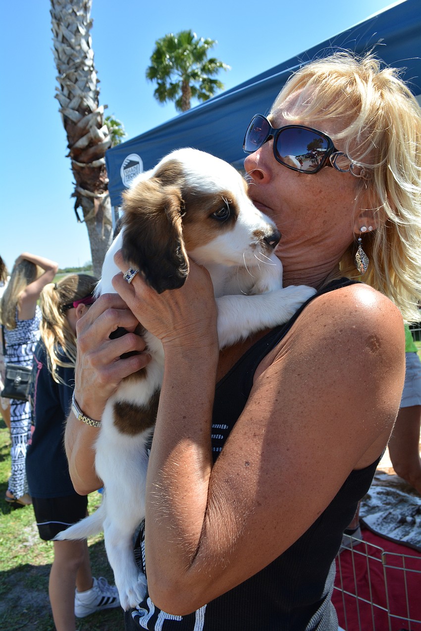University Park'    s Brenda Gradl gets puppy kisses from Harrison.