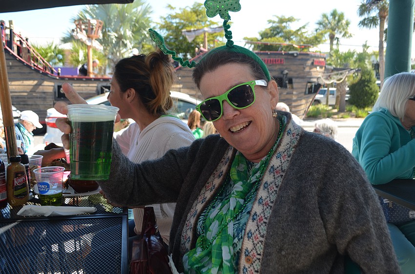 Linda Mercurio holds up her green beer.