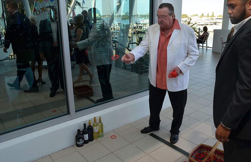 Rick Slayback performs the winning toss that earned him two bottles of wine at Miracle Ball on March 25 at Sarasota Yacht Club.