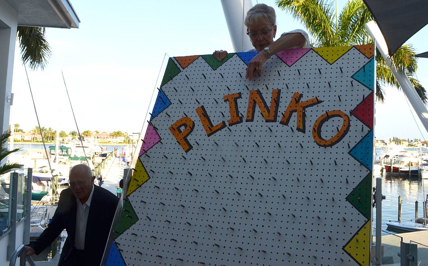 Micki Sellman watches her washer drop to the bottom of the board while playing plinko at Miracle Ball on March 25 at Sarasota Yacht Club.